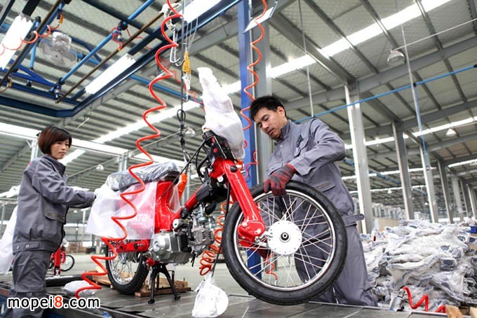 重慶安第斯摩托車(chē)技術(shù)工人在自動(dòng)成車(chē)流水生產(chǎn)線組裝摩托車(chē)